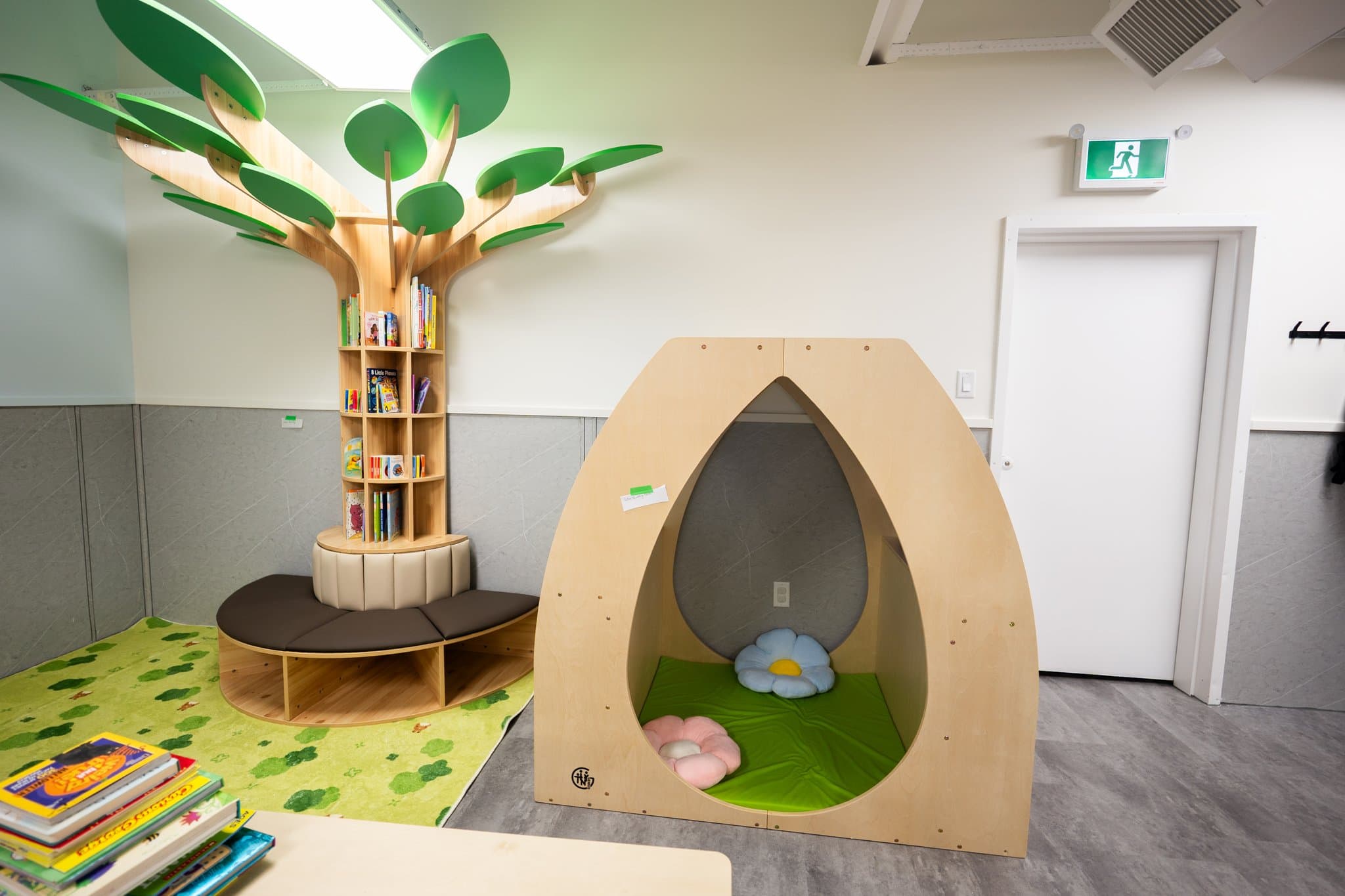 Bright licensed daycare classroom in Summerside Edmonton featuring custom wooden tree library reading nook and open play space